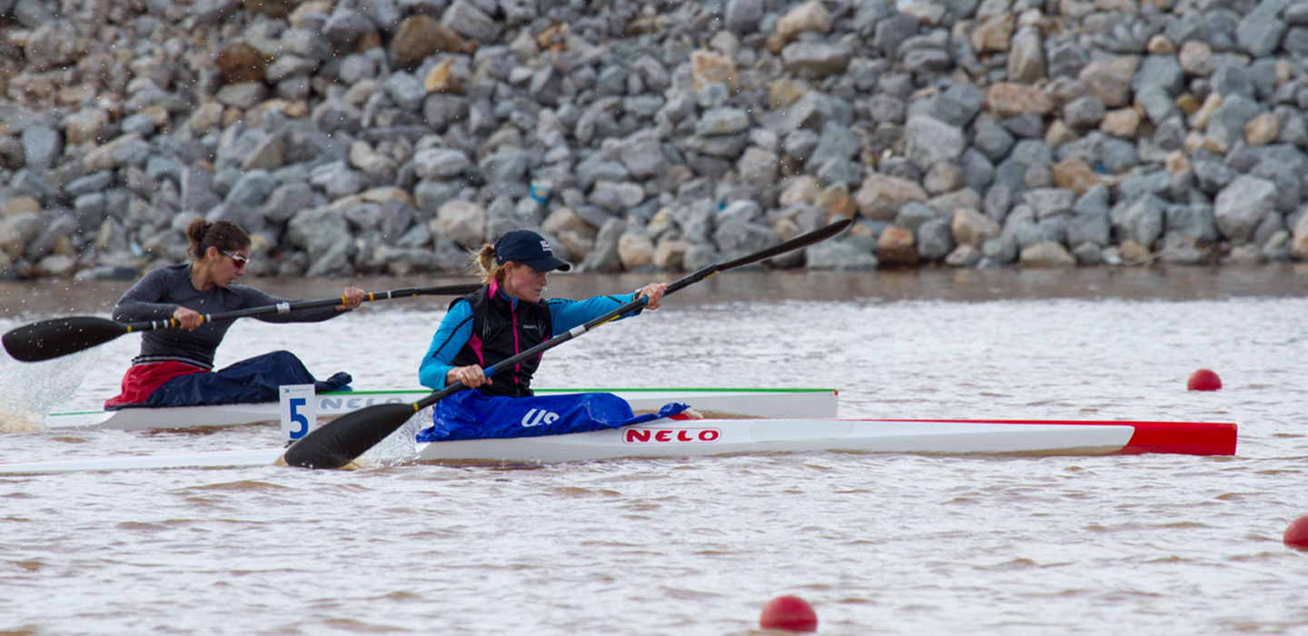 Image of Two female sprint kayakers racing on the Oklahoma River